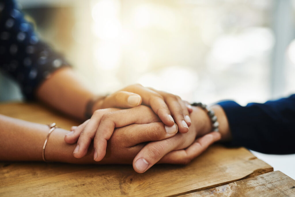 Closeup shot of two unrecognizable people holding hands in comfort